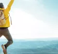 man on top of a mountain jumping in the air