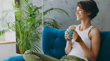 Woman relaxing on her sofa with a drink