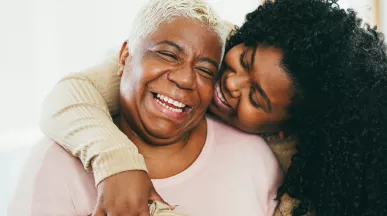 Old and young black women hugging and smiling