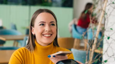 woman paying with phone is cafe