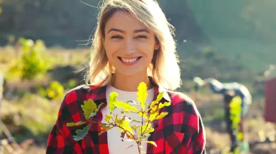 woman in a field holding a plant