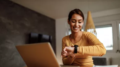woman at desk checking her watch