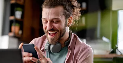 Man on phone at desk looking happy