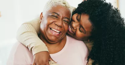 Old and young black women hugging and smiling