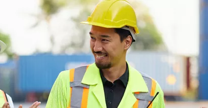 group of people on a construction site clapping their collgeaue