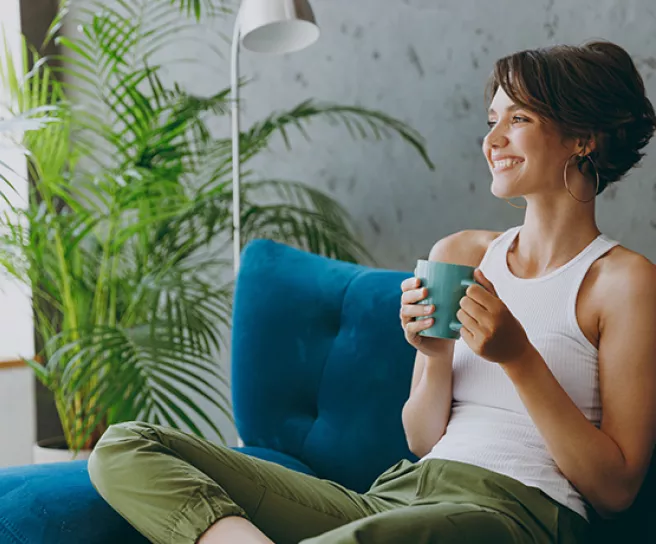 Woman relaxing on her sofa with a drink